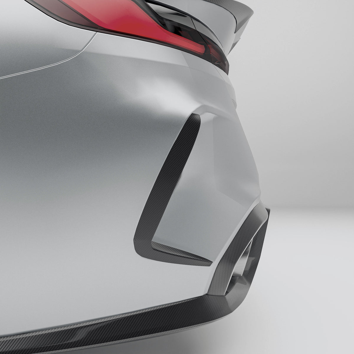 Close-up of a car's rear bumper with carbon fiber texture on a gray background